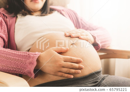 Happy pregnant woman and expecting baby at home. Happy pregnant woman and expecting baby at home. 65795221