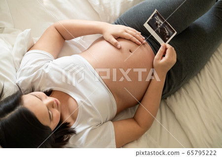 Happy pregnant woman and expecting baby at home. Happy pregnant woman and expecting baby at home. 65795222
