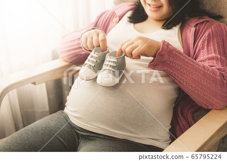 Happy pregnant woman and expecting baby at home. Happy pregnant woman and expecting baby at home. 65795224