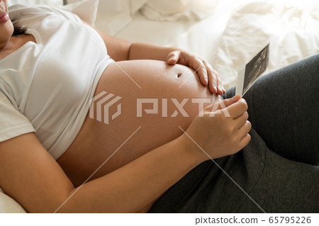 Happy pregnant woman and expecting baby at home. Happy pregnant woman and expecting baby at home. 65795226