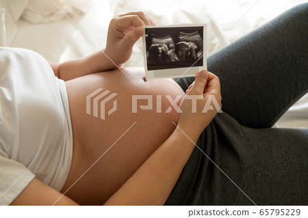 Happy pregnant woman and expecting baby at home. Happy pregnant woman and expecting baby at home. 65795229