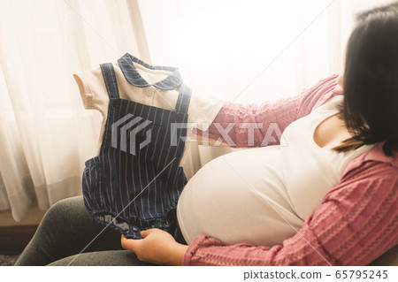 Happy pregnant woman and expecting baby at home. Happy pregnant woman and expecting baby at home. 65795245