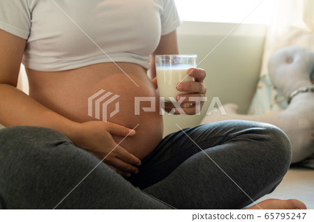 Happy pregnant woman and expecting baby at home. Happy pregnant woman and expecting baby at home. 65795247