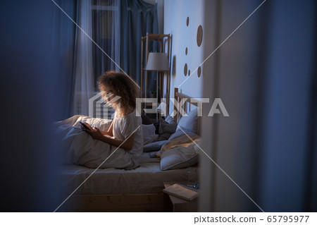 Young Woman Using Digital Tablet in Bed Young Woman Using Digital Tablet in Bed 65795977