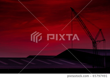 Construction crane against pink sky and clouds. 65797491