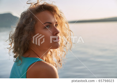 Portrait of serious pretty girl on background of lake. Portrait of serious pretty girl on background of lake. 65798023