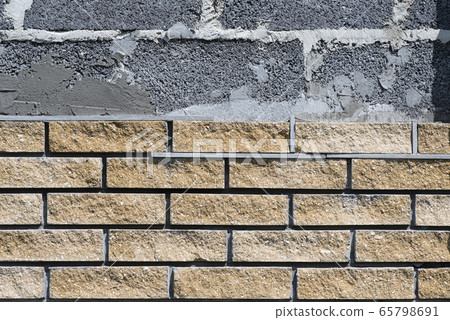 Wall cladding with decorative bricks, front view. Material for decorating the wall of house or fence 65798691