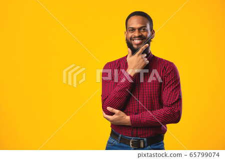 Portrait of black guy looking at camera at studio 65799074