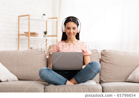 Girl listening to music online in headphones 65799854