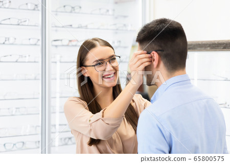 Portrait of lovely young couple choosing spectacles Portrait of lovely young couple choosing spectacles 65800575