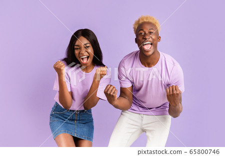 African American couple shouting OMG, happy over victory or success on lilac background 65800746