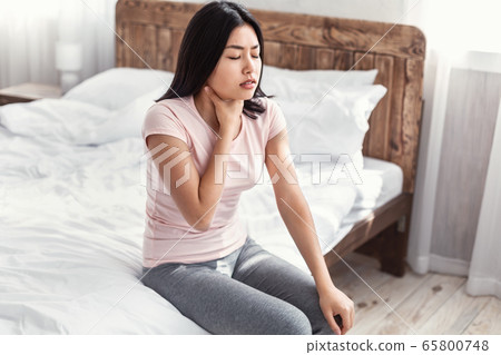 Asian Girl Touching Sore Throat Sitting In Bed At Home 65800748
