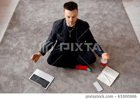 Reflective man with laptop sit in lotus on carper  65800986