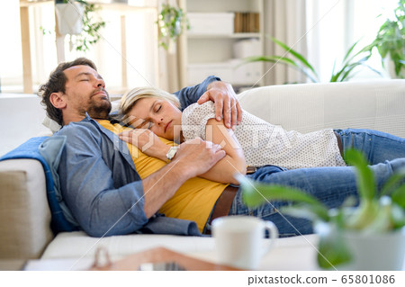Happy couple in love on sofa indoors at home, sleeping. 65801086