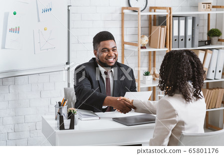 Personnel manager and young job applicant shaking hands at modern company office Personnel manager and young job applicant shaking hands at modern company office 65801176