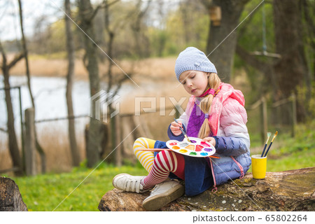 Little girl paints in the spring on nature 65802264