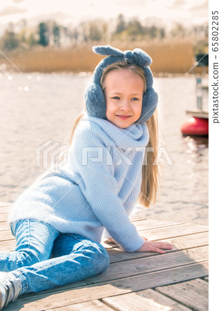 Little girl resting sitting by the river in spring nature 65802285