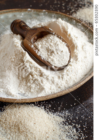 Raw fonio flour and seeds with a spoon on dark Raw fonio flour and seeds with a spoon on dark 65802890