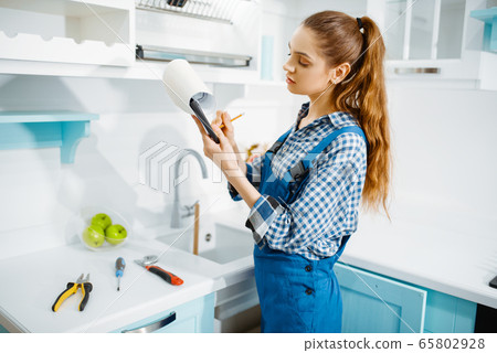 Female furniture maker in uniform holds notebook 65802928