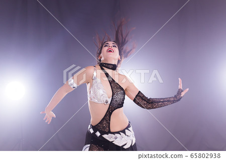 Spirituality dance. Beautiful sexy woman with luxury glossy eastern make-up dancing tribal fusion. Belly dance. Spirituality dance. Beautiful sexy woman with luxury glossy eastern make-up dancing tribal fusion. Belly dance. 65802938