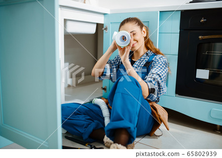 Female plumber lying on the floor, top view Female plumber lying on the floor, top view 65802939