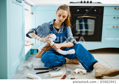 Female plumber fixing problem with drain pipe 65802941