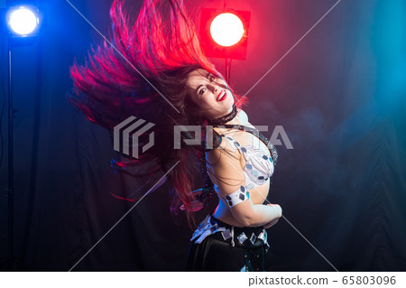 Young woman dancing in Tribal Fusion style. Belly dance on the stage. 65803096