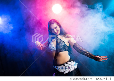 Young woman belly dancer in exotic dress with gold, dancing tribal fusion dance in studio. 65803101