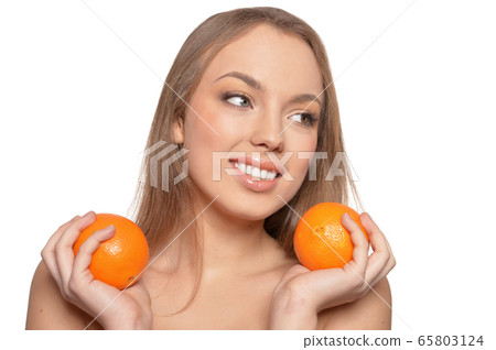 Portrait of young woman posing with oranges 65803124