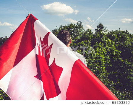 Attractive man holding Canadian Flag. National 65803853