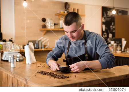 Barista preparing coffee in a coffee shop. Professional coffee making, service and catering concept 65804074