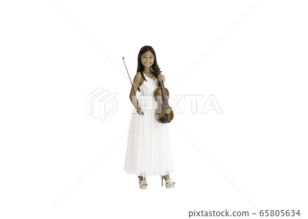 A portrait of a cute, elementary school Asian girl with long hair and wearing a white evening dress holding her violin.  65805634