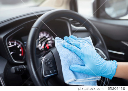 Staff is cleaning the inside of the car  to 65806438