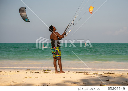 Young Attractive Muscular and Strong Athletic Black African Man Kite Surfing Instructor Teacher at the White Sand Beach 65806649