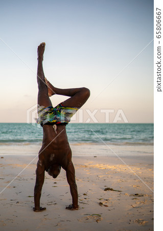 Young Attractive Muscular and Strong Athletic Black African Man at the White Sand Beach Training Acrobatics and Handstand Young Attractive Muscular and Strong Athletic Black African Man at the White Sand Beach Training Acrobatics and Handstand 65806667