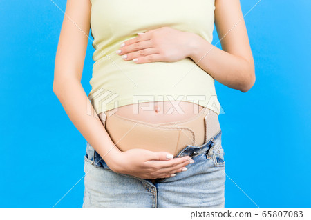 Close up of pregnancy bandage dressed on pregnant 65807083