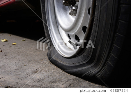 Selective focus flat tire of old car park on the street 65807324