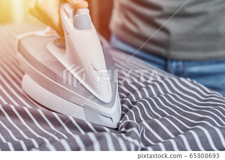 Woman ironing clothes on the ironing board 65808693