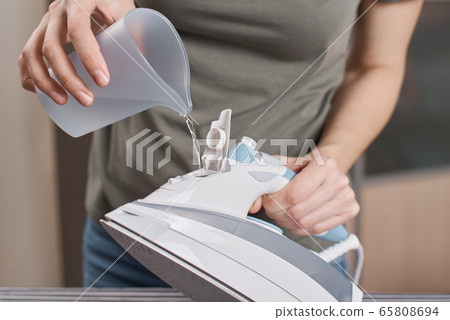 Woman load water in the iron. Prepare iron 65808694