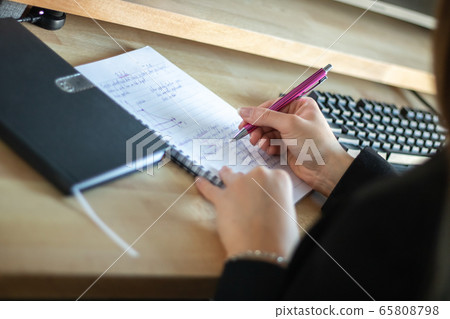 Coronavirus. Home working with computer. female hands writing to diary Coronavirus. Home working with computer. female hands writing to diary 65808798