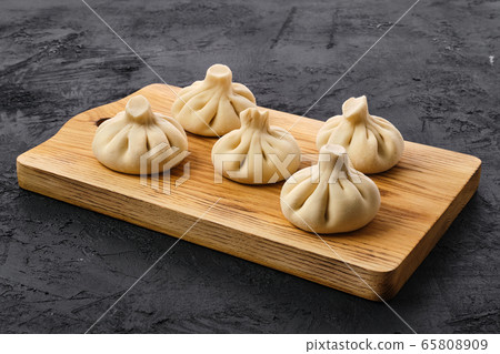 Uncooked khinkali on wooden board Uncooked khinkali on wooden board 65808909