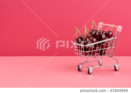 Fresh juicy cherries in shopping wheel basket 65808968