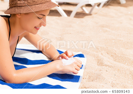 Closeup of woman putting sun cream on hand before Closeup of woman putting sun cream on hand before 65809143