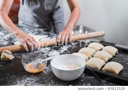 Young woman rolling dough with long pin for samsa 65811520