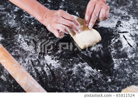 Female hands folding meat stuffed raw puff pastry 65811524