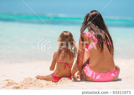 Mom with little daughter on the beach. 65811973