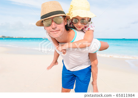 Little girl and happy dad having fun during beach vacation Little girl and happy dad having fun during beach vacation 65811984