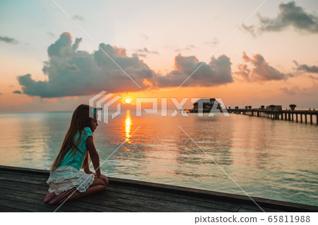 Adorable little girl on the beach at sunset Adorable little girl on the beach at sunset 65811988