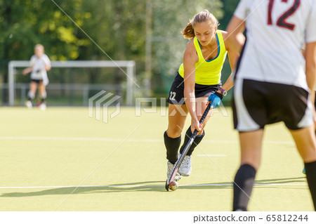 Field hockey female player lead the ball in attack Field hockey female player lead the ball in attack 65812244