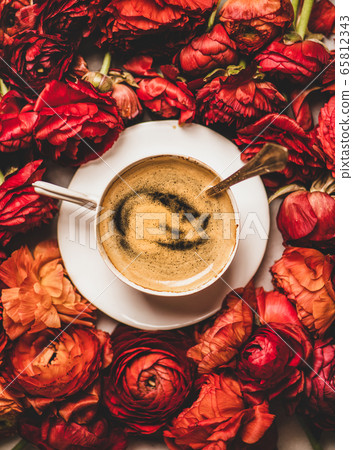 Black espresso coffee in cup on red ranunculus 65812343